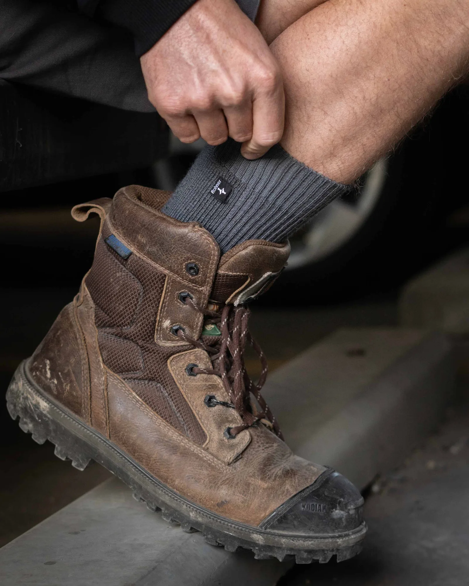 Graue Rohner Army Working Socke wird in einen Lederstiefel gezogen
