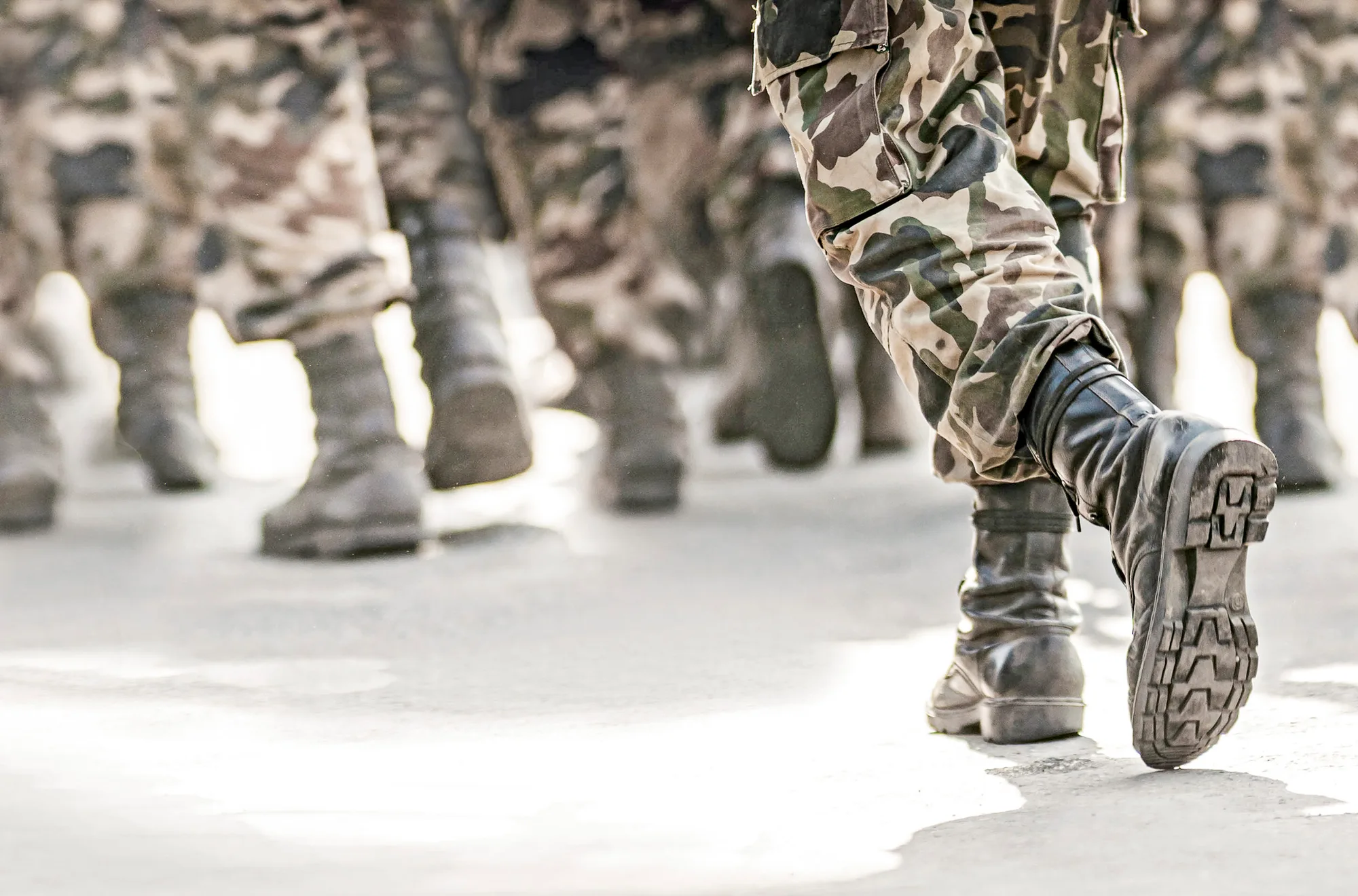 Soldaten in Tarnhosen und Kampfstiefeln auf dem Marsch